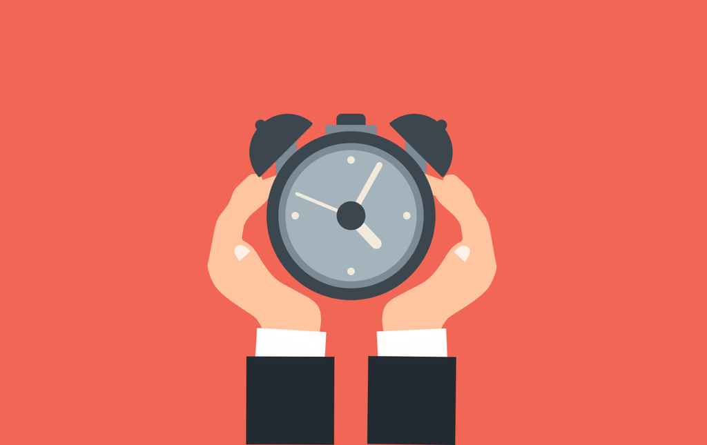 A hand holding an alarm clock on a red background.