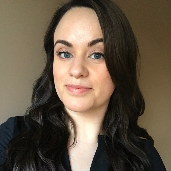 A woman wearing a black shirt with long brown hair.